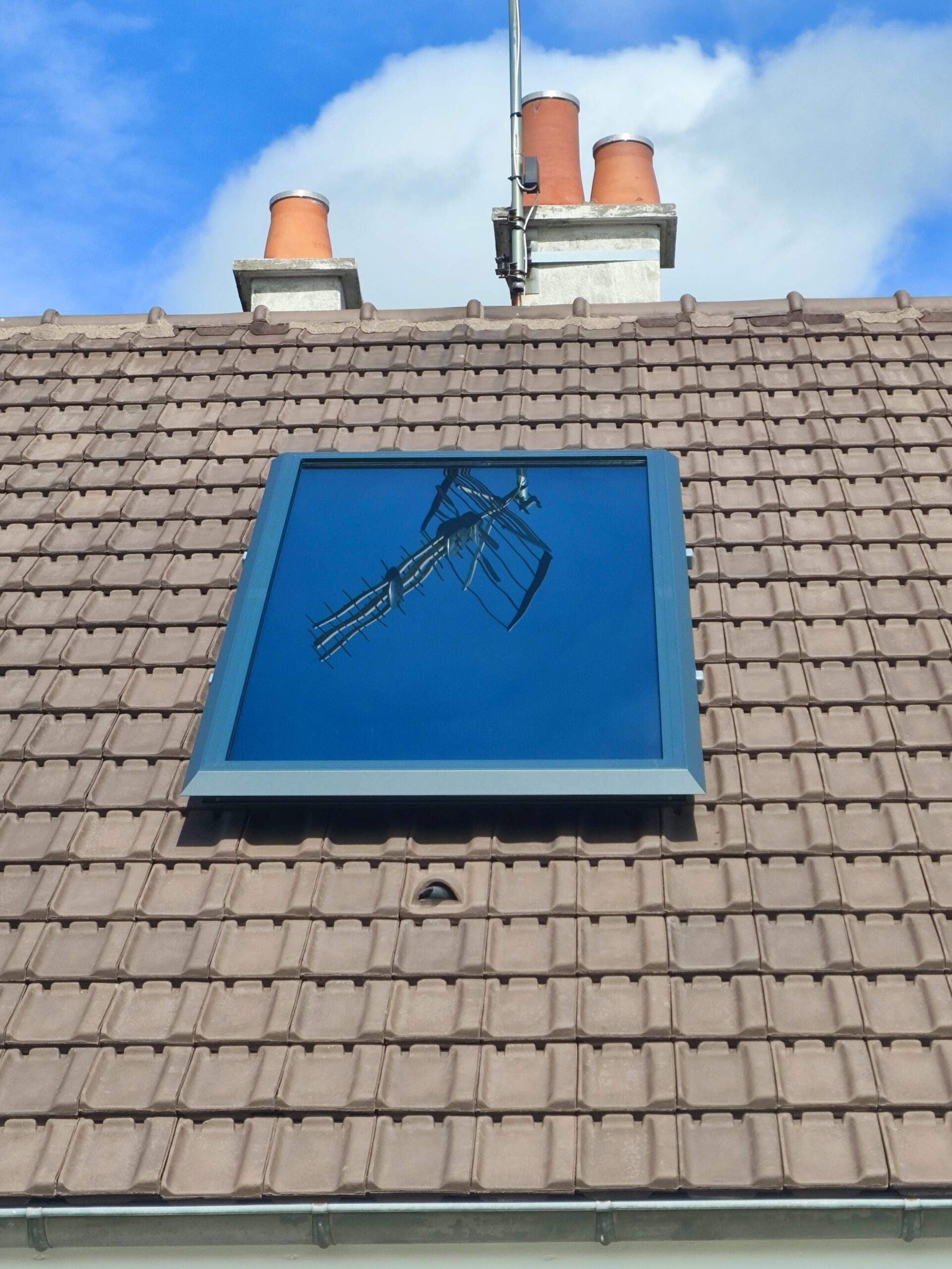 Installation chauffe air solaire en toiture avec reflet d'une antenne hertzienne